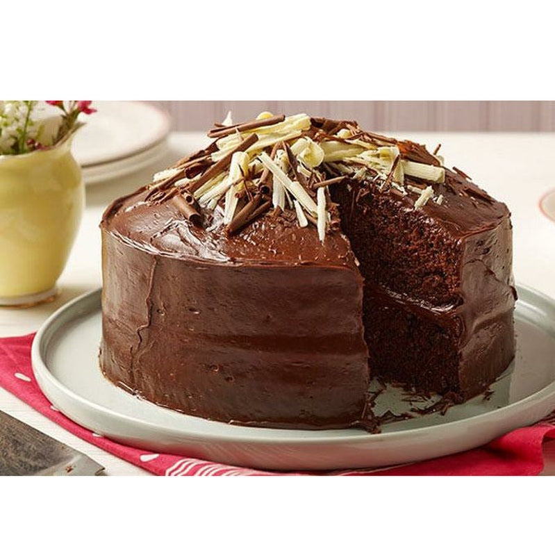 Un gâteau au chocolat sur une assiette grise qui est sur une table blanche avec une serviette rouge